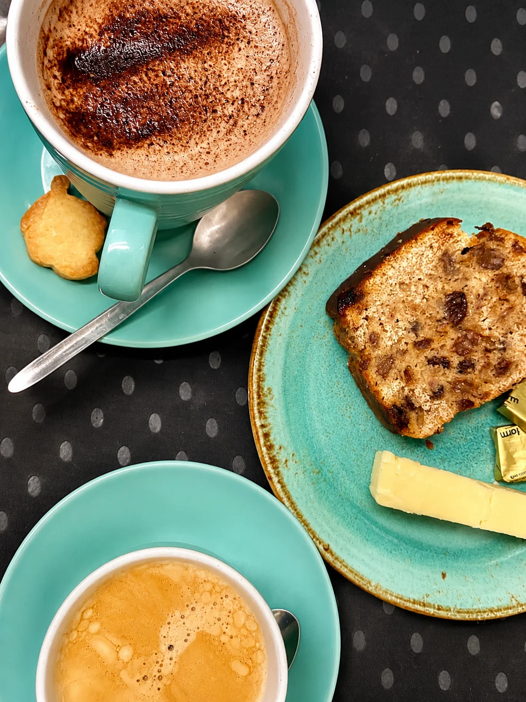 Two hot drinks served with toasted fruit loaf